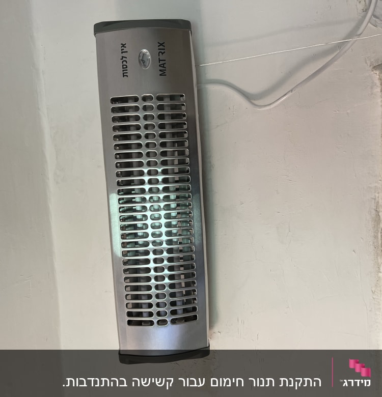 תנור חימום חשמלי מותקן על קיר עם כבל חשמל